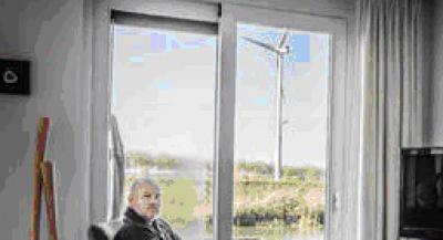 © Jörgen Caris. Bewoner Maurice Bakker met voor zijn deur één van de gewraakte windmolens.